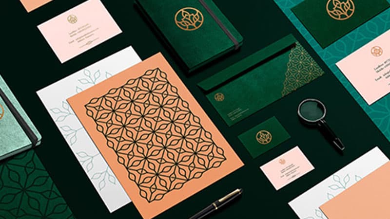 Luxury brand identity with green and peach patterned stationery
