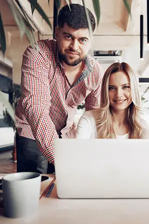 Two designers reviewing a project on a laptop