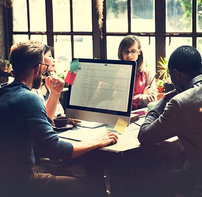 Team reviewing a website design on a desktop monitor