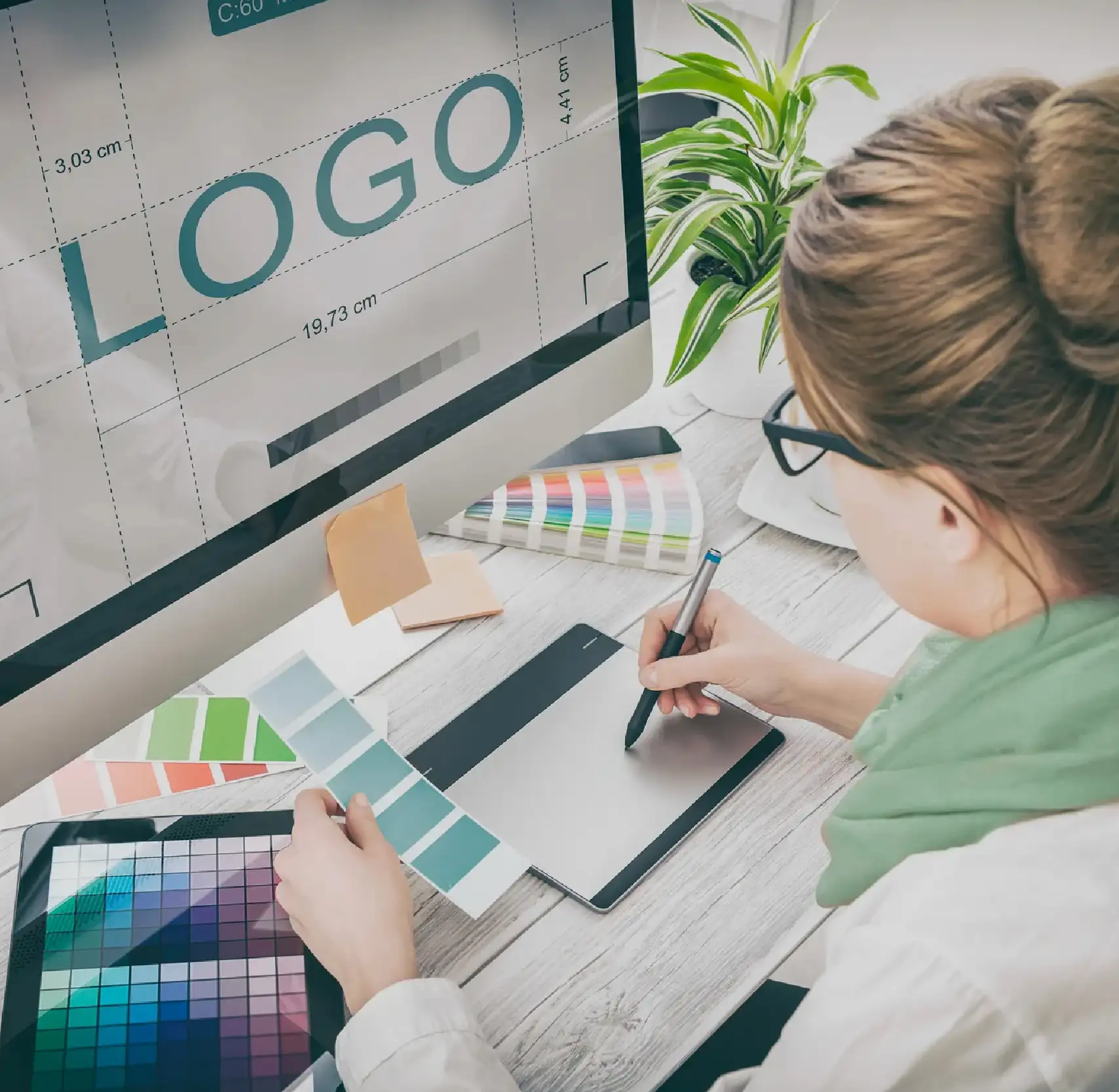 Designer sketching logo ideas beside color swatches